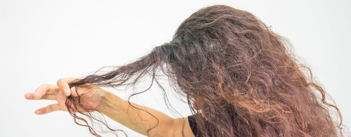 Mujer tirando de su pelo encrespado