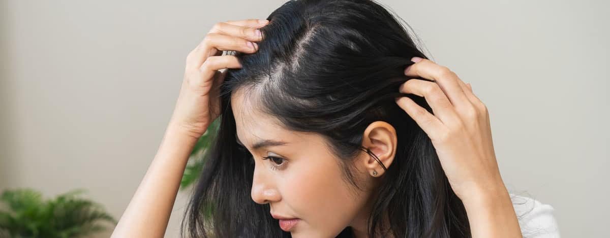 mujer observando perdida de densidad de cabello en si misma
