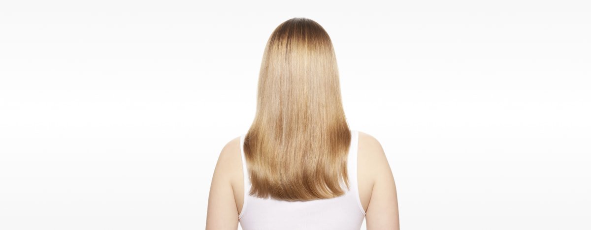 Mujer con el cabello visiblemente reparado, mostrando mayor fuerza, suavidad y brillo tras seguir la guía definitiva para reparar el cabello dañado.