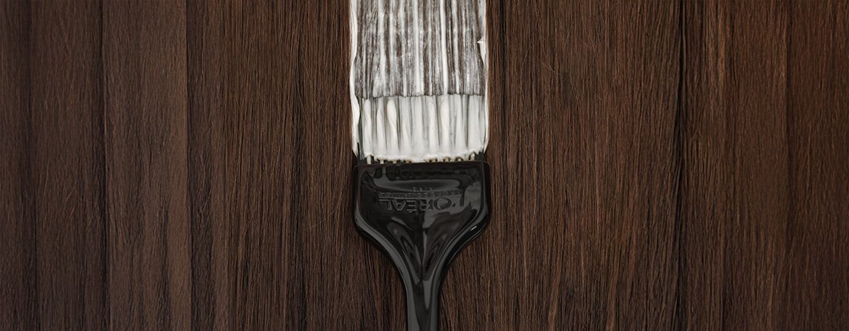 El vídeo se centra en una brocha de peluquería profesional que aplica tinte al cabello, ilustrando las técnicas utilizadas para cubrir las canas de forma eficaz.
