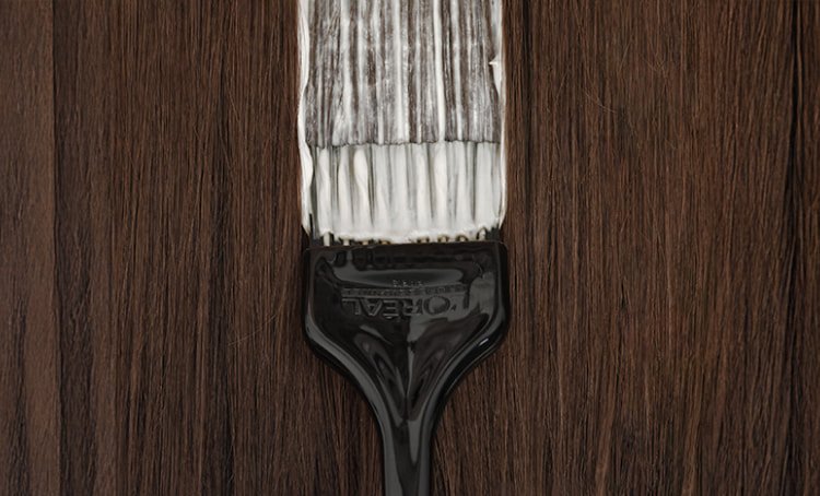 El vídeo se centra en una brocha de peluquería profesional que aplica tinte al cabello, ilustrando las técnicas utilizadas para cubrir las canas de forma eficaz.