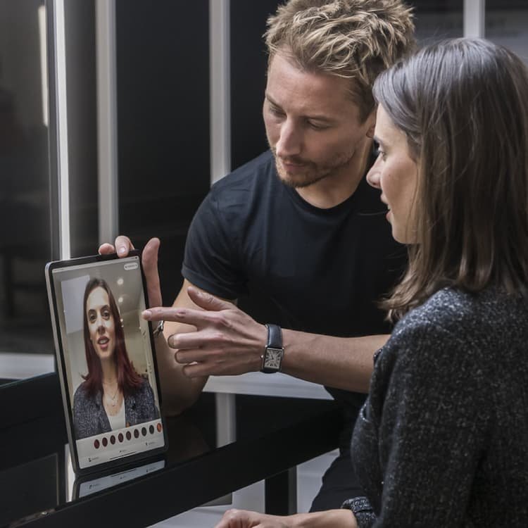 Una mujer y estilista utiliza la aplicación de color My Hair [iD] para una experiencia de color personalizada, la primera herramienta profesional que complementa los servicios de salón.